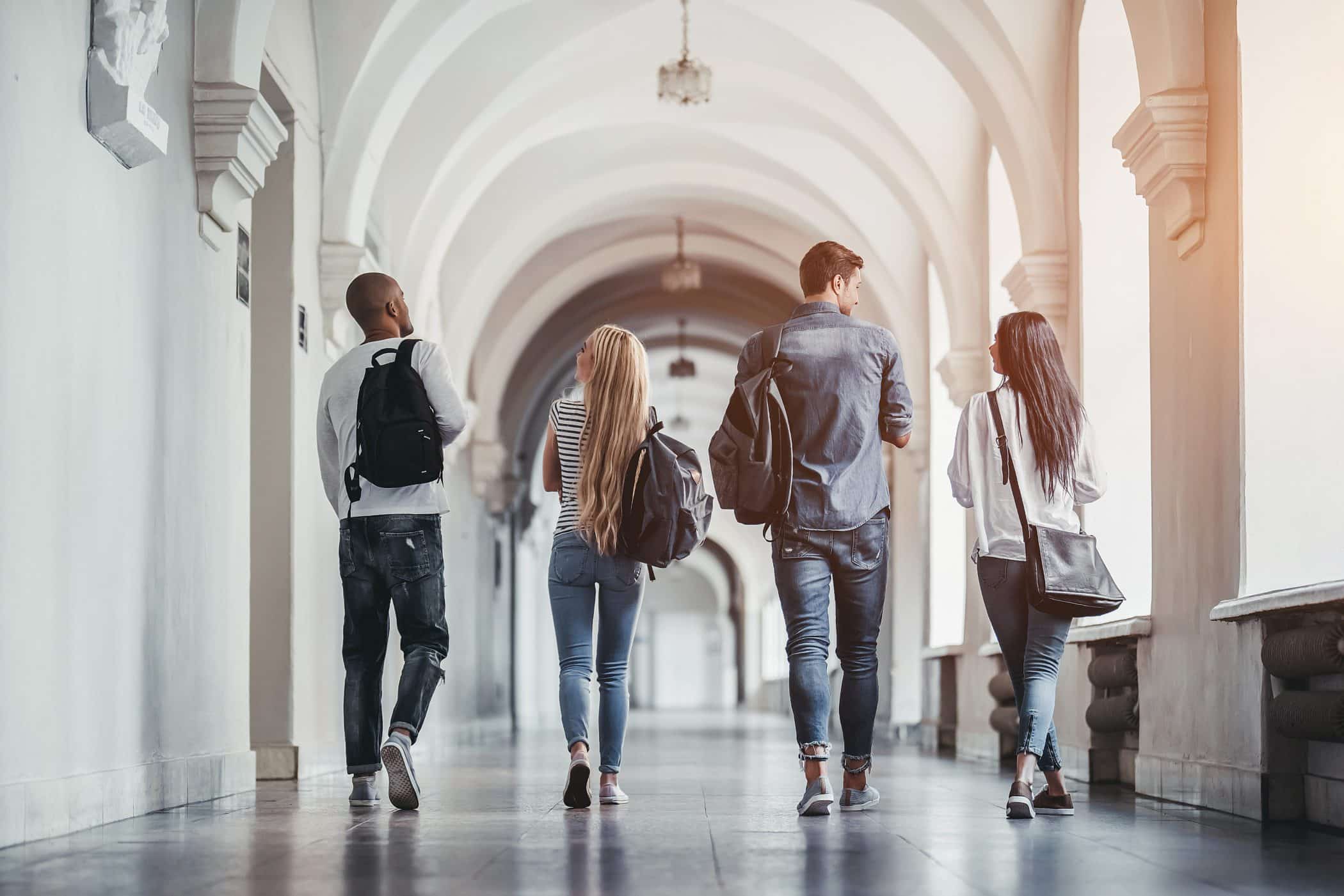 Group of students walking through a college hallway